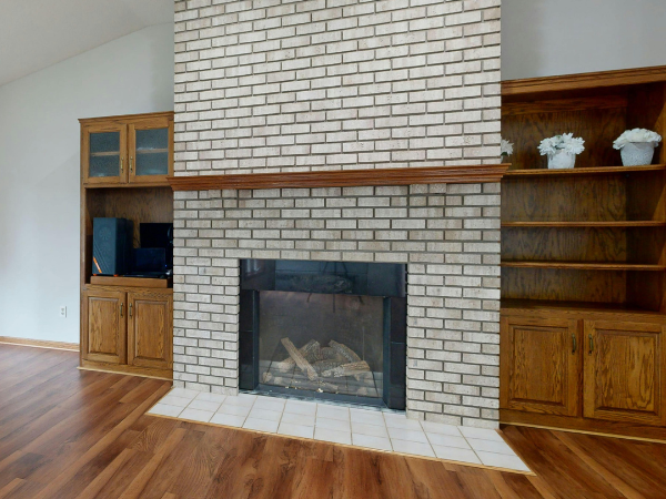 Technician installing a modern fireplace unit inside a home.