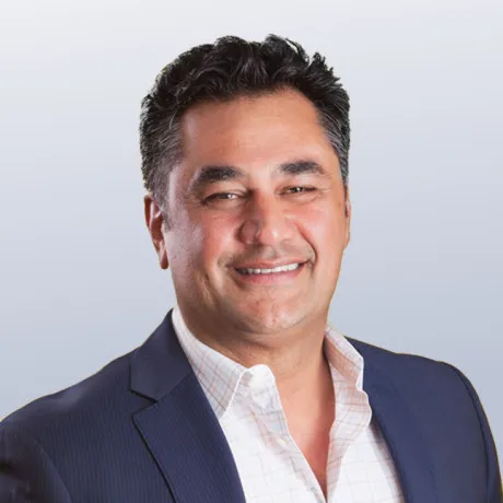 Picture of Babak Hedayati smiling wearing a dark blue blazer with a white dress shirt open at the collar