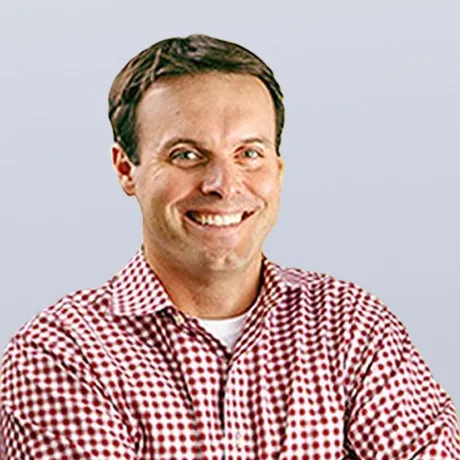 Picture of Colby West smiling in a red and white check print collared shirt
