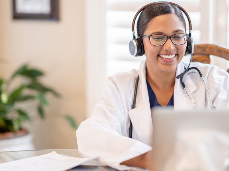 doctor providing telehealth consultation on laptop with headset