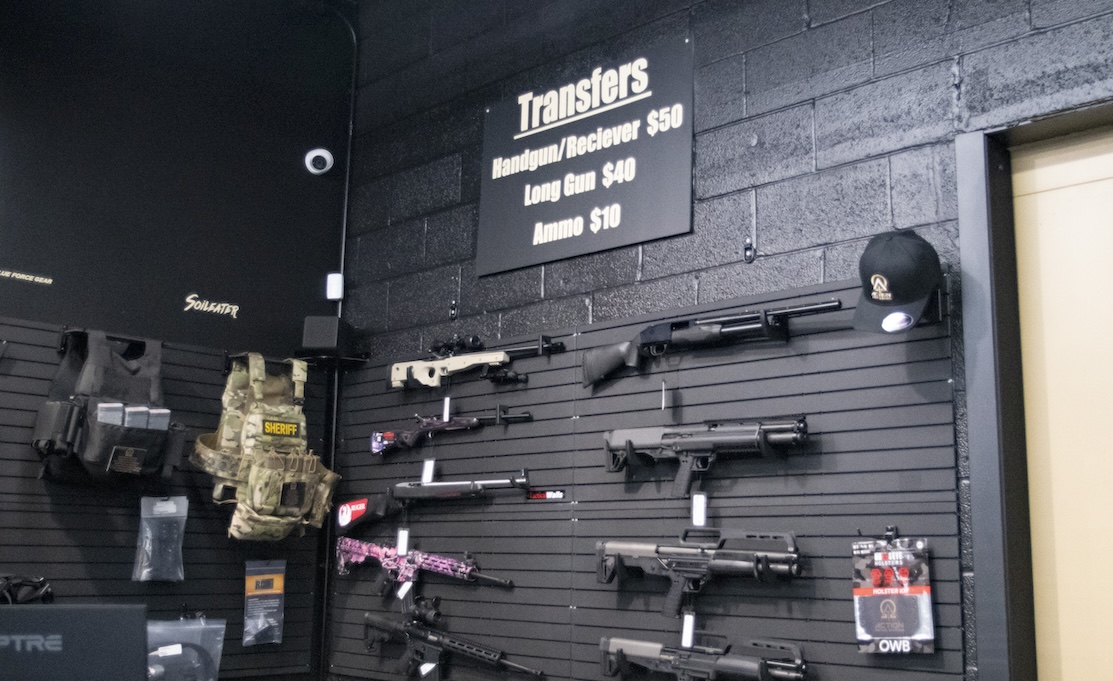 guns and firearm accessories on wall display of store