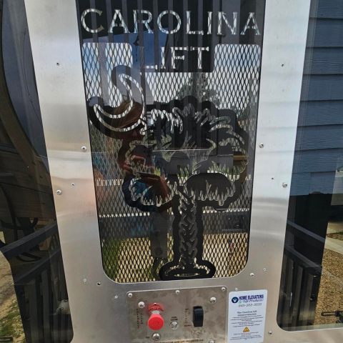 Metal panel with CAROLINA LIFT text and palmetto tree cutout, red emergency button below.