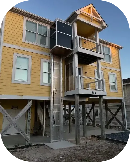 Fully Enclosed Carolina Lift installed on a yellow house
