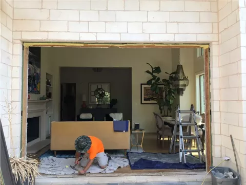worker kneeling in a doorway, preparing for installation