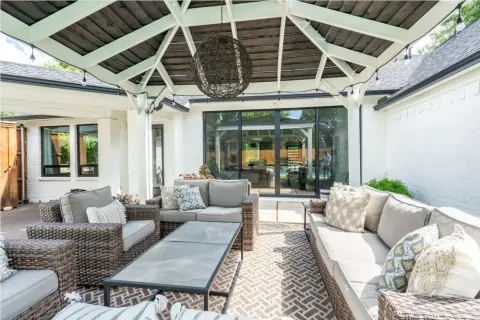 covered patio with wicker sofas, patterned rug, and a large coffee table