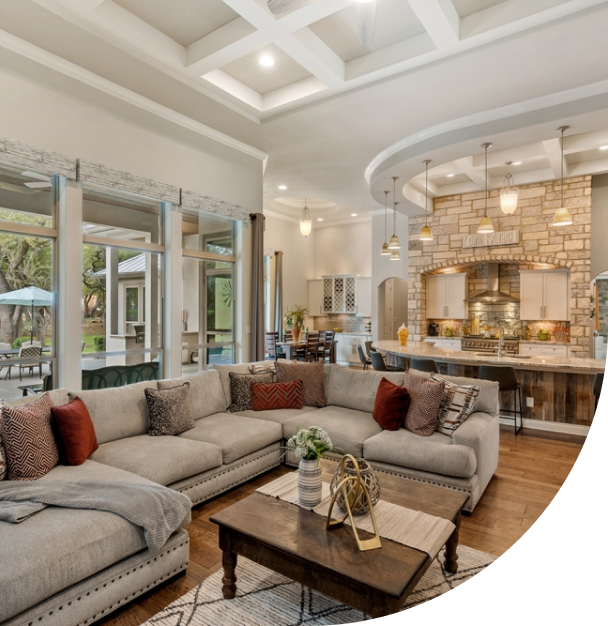 modern open-concept living room and kitchen with a large gray sectional sofa and pendant lights