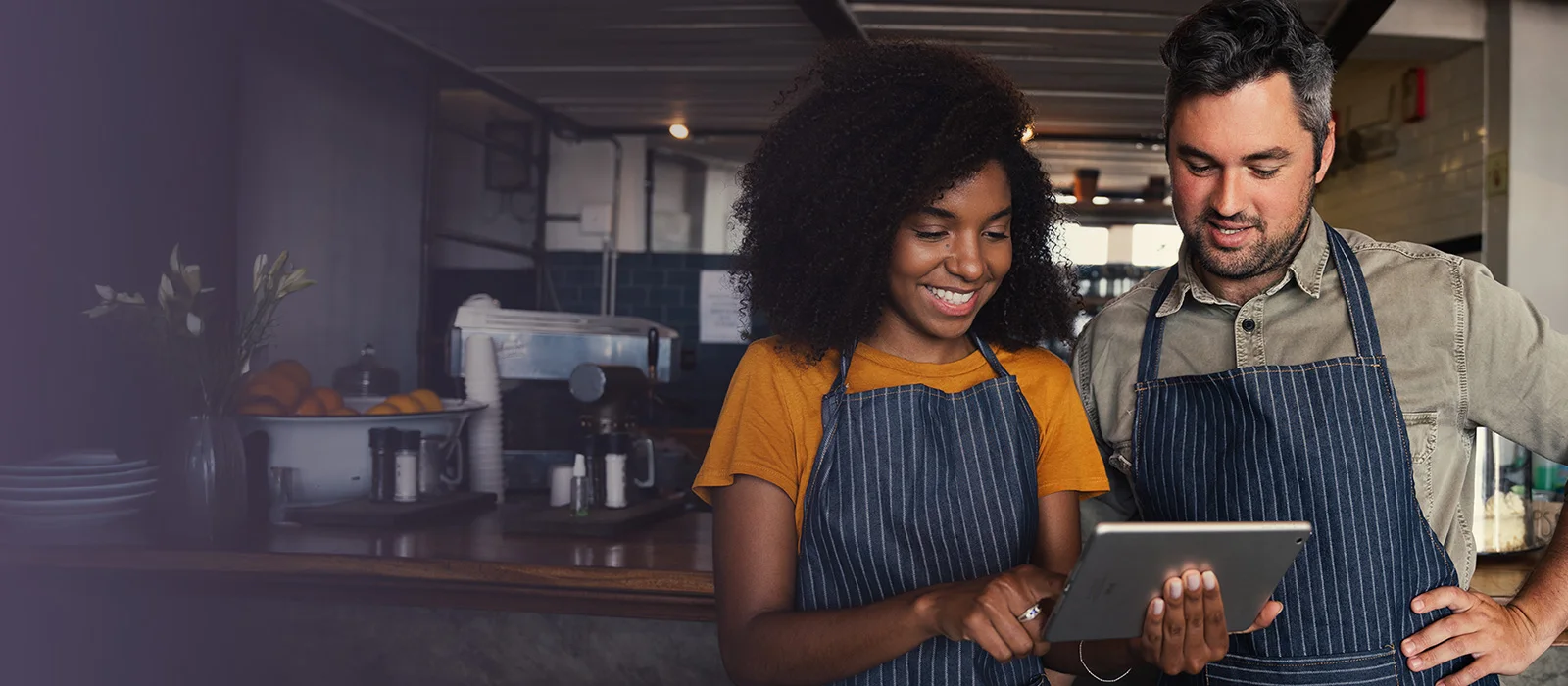 2 people showing a laptop with results from a marketing campaign for their restaurant in rochester ny