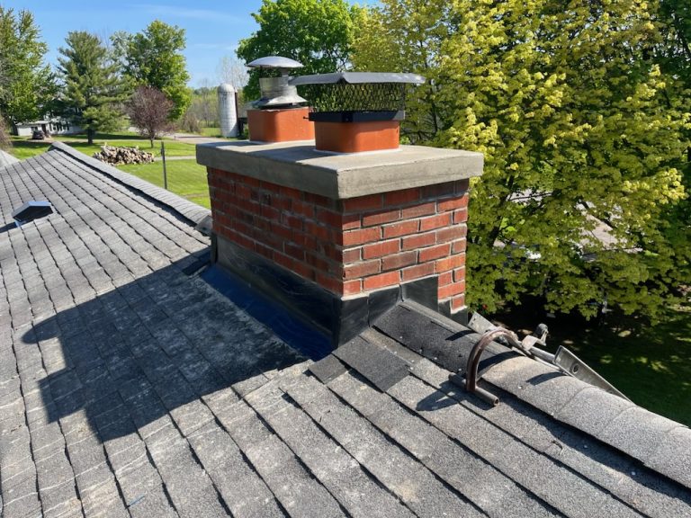 outdoor air conditioning unit surrounded by green bushes