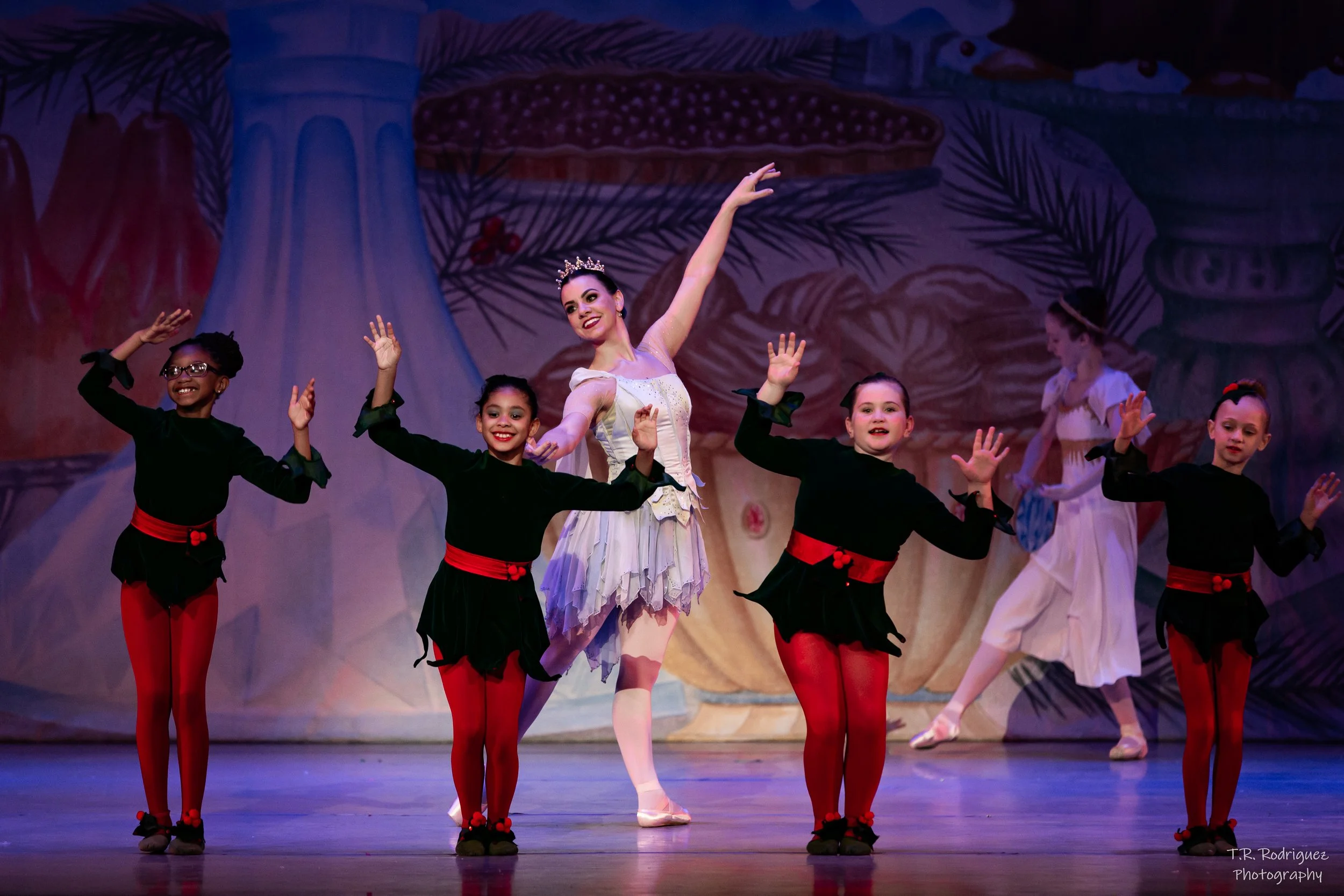 A group of young ballet dancers performing on stage.