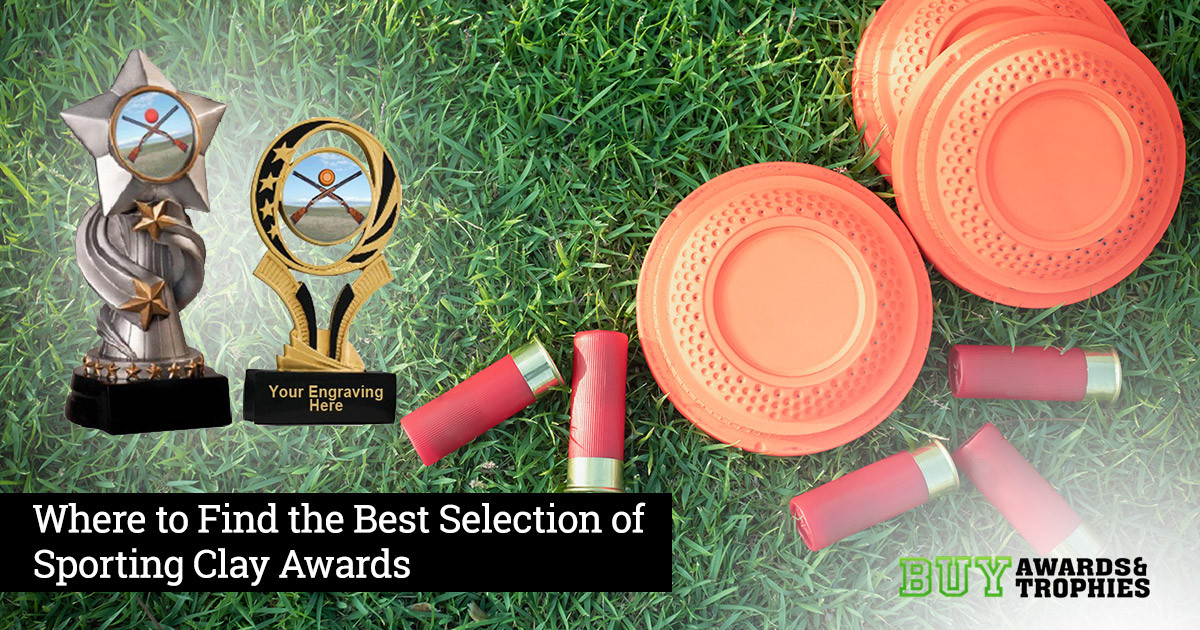 Clay disks and shotgun shells in grass with trophies and awards