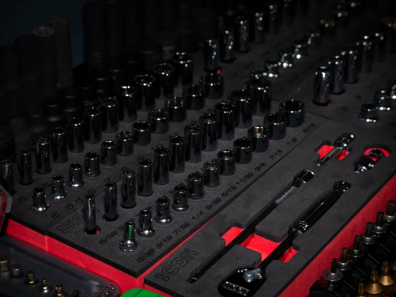 A set of organized socket wrenches and tools in a foam-lined case