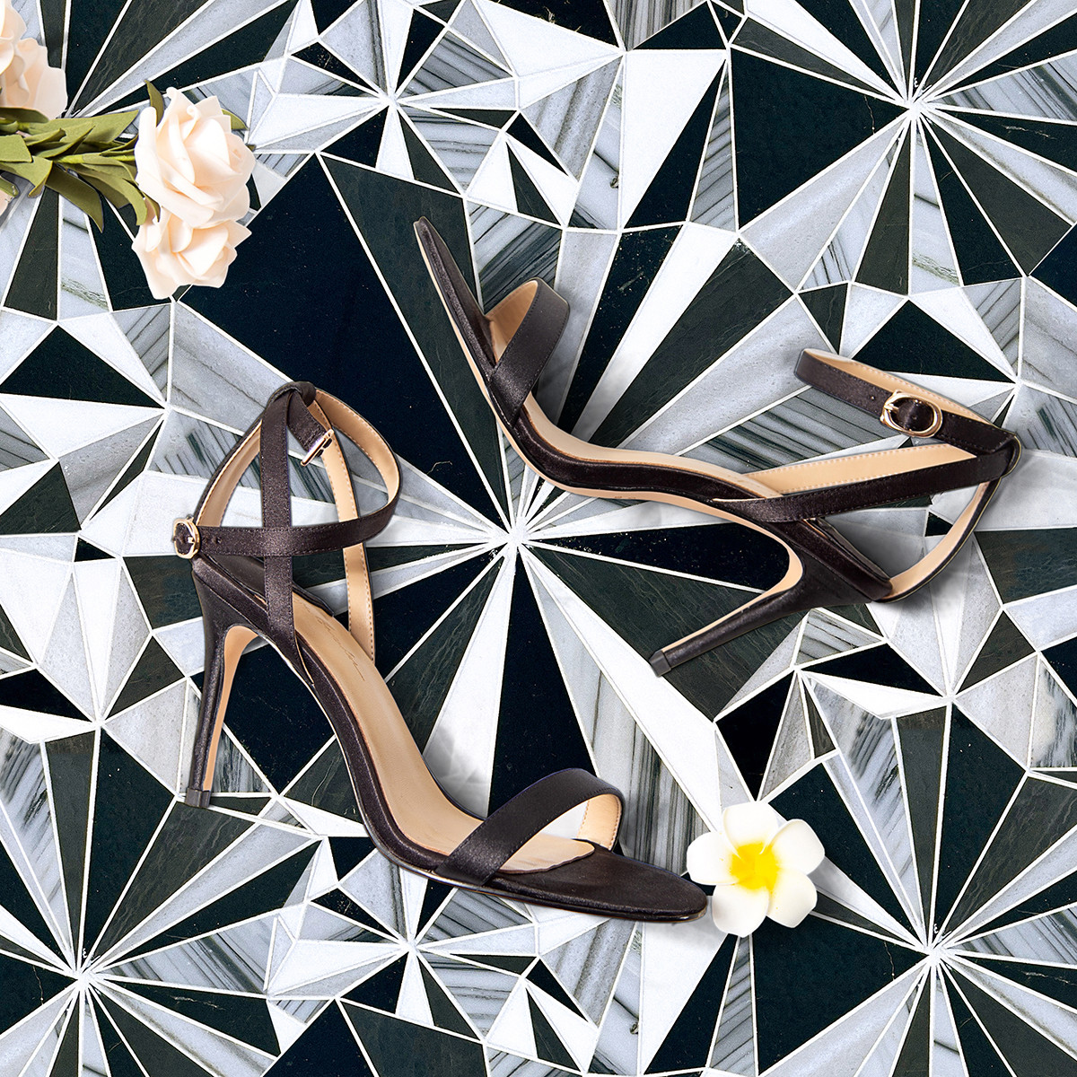 A black, white, and gray mosaic pattern on a bathroom wall.