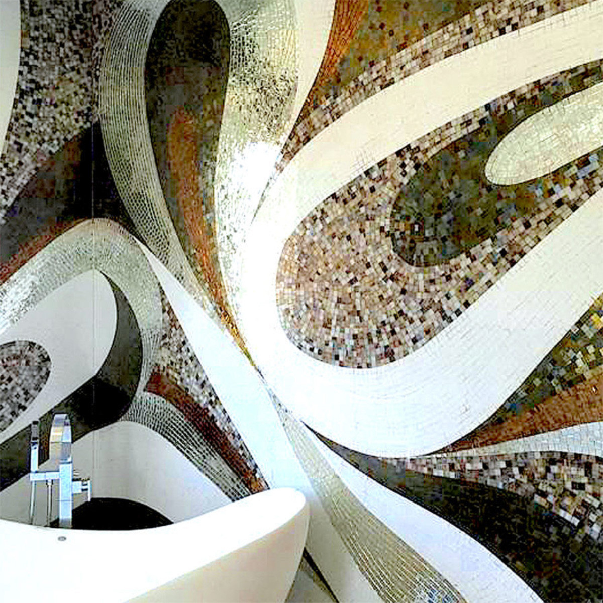 A white, green, and brown mosaic pattern on a bathroom wall.