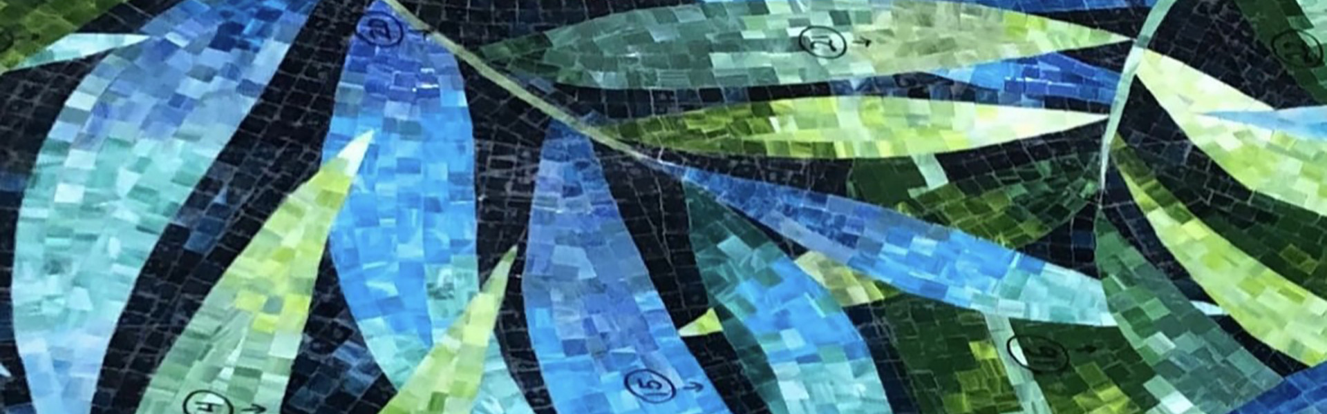 A mosaic of blue and green leaves made from small, square tiles on a dark background.