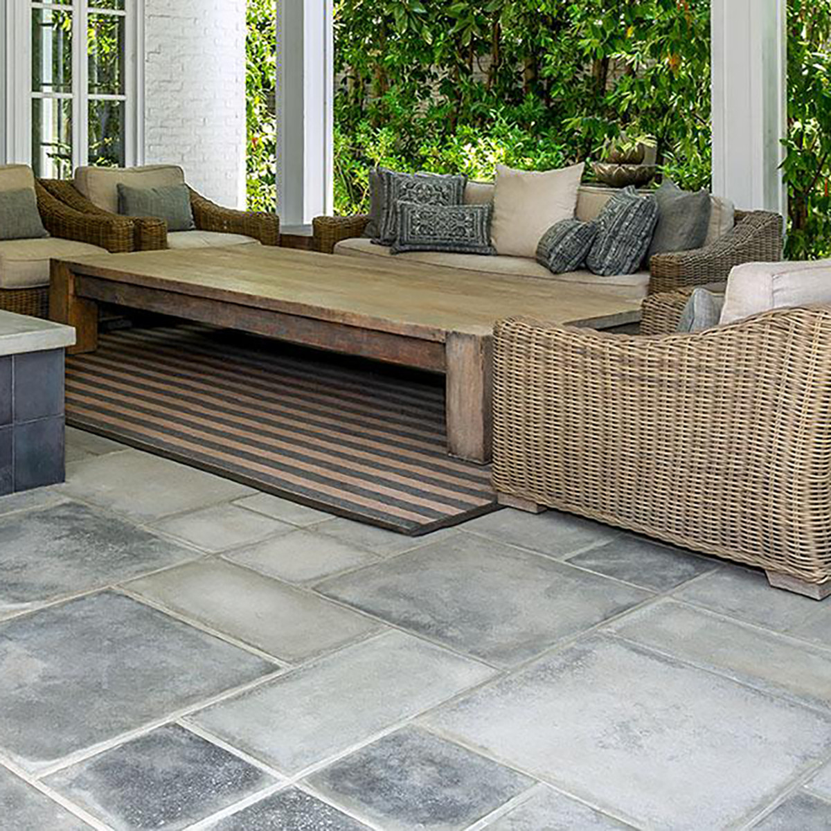 Outdoor patio with stone flooring and wicker furniture