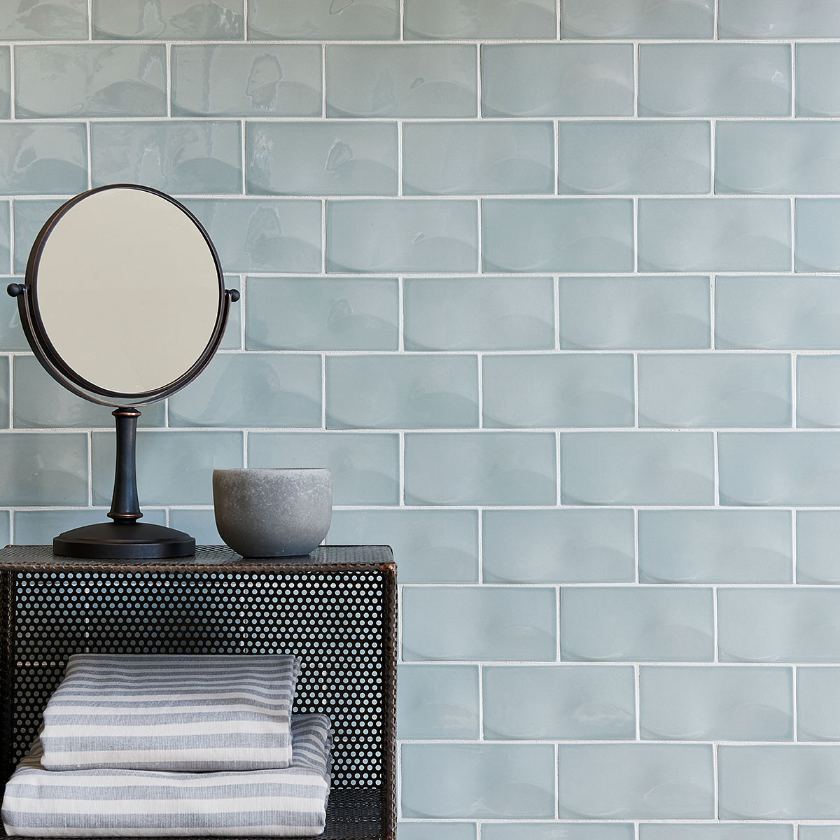 blue ceramic tile wall with mirror and towels