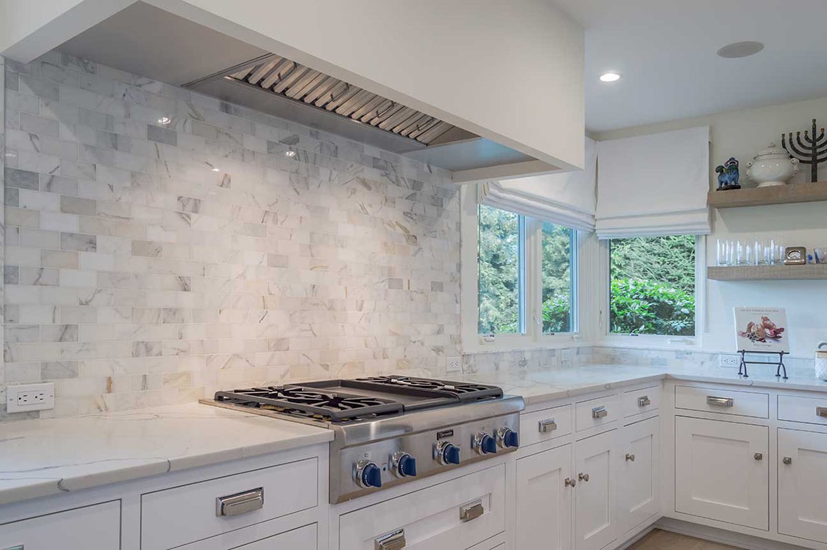 marble kitchen backsplash with white cabinets and stove