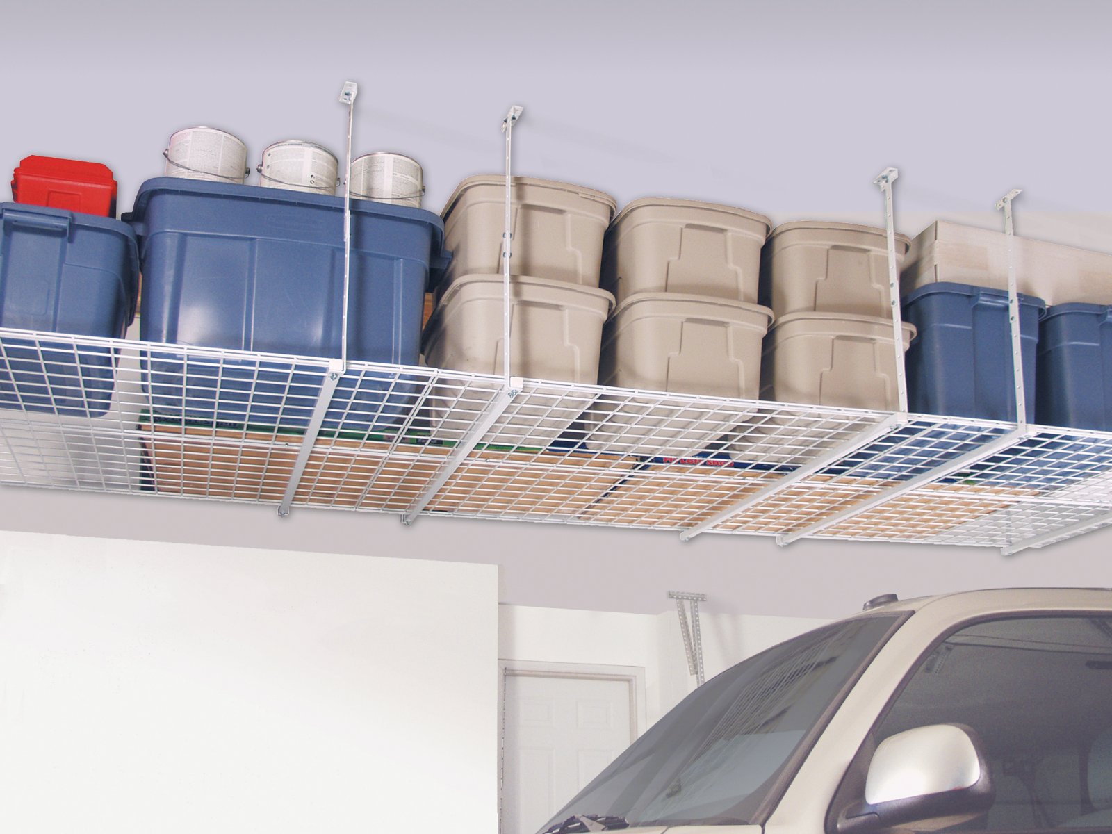 Overhead metal garage shelf storing plastic bins and boxes above a parked car.