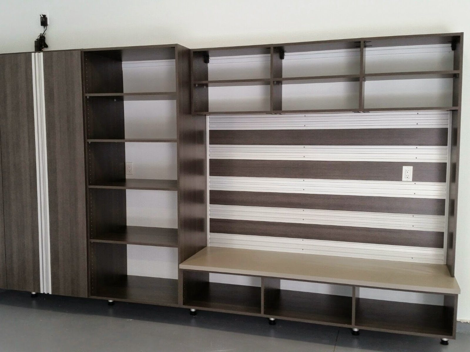 Wall-mounted wooden storage unit with open shelves, cubbies, and a built-in bench.