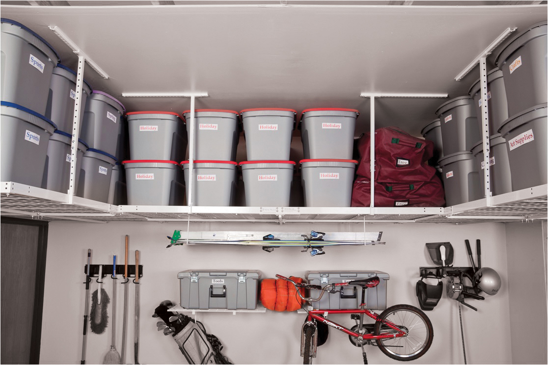 Plastic storage bins and bags are organized on overhead shelves in a tidy garage.