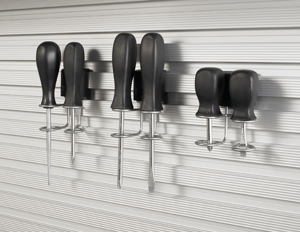 Six screwdrivers with black handles hanging on a gray slotted wall organizer.