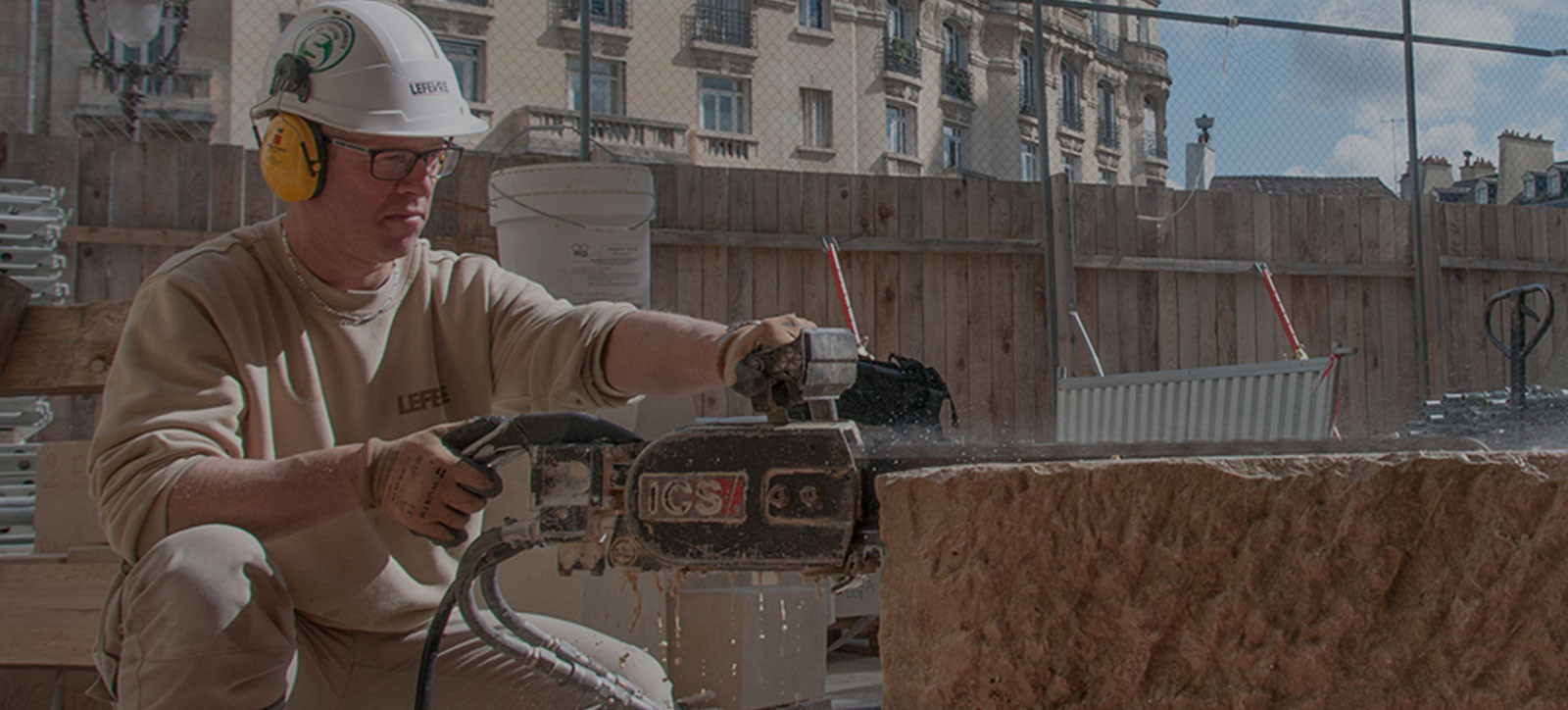 construction worker using chainsaw on stone