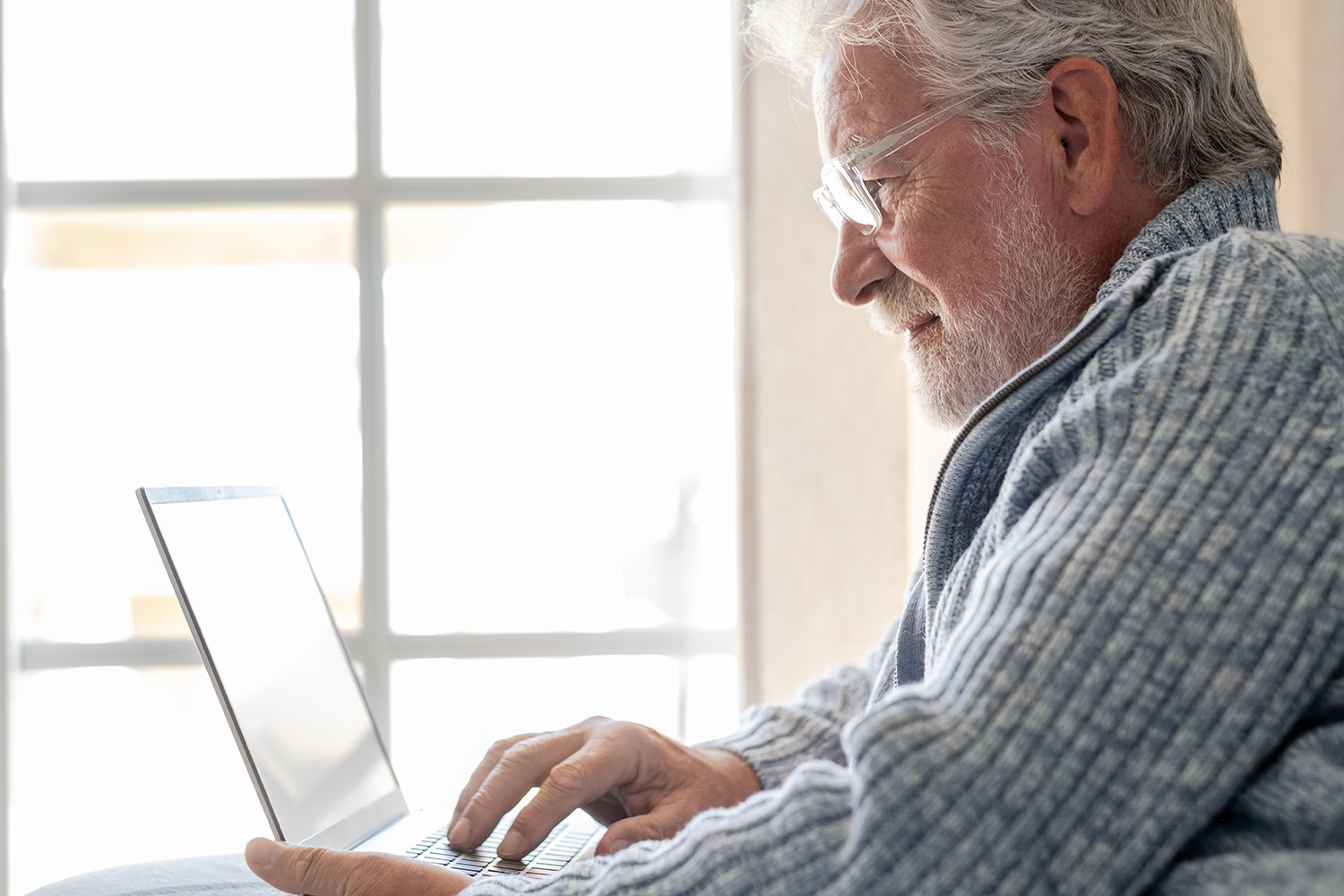 A man sitting on a couch using a laptop.