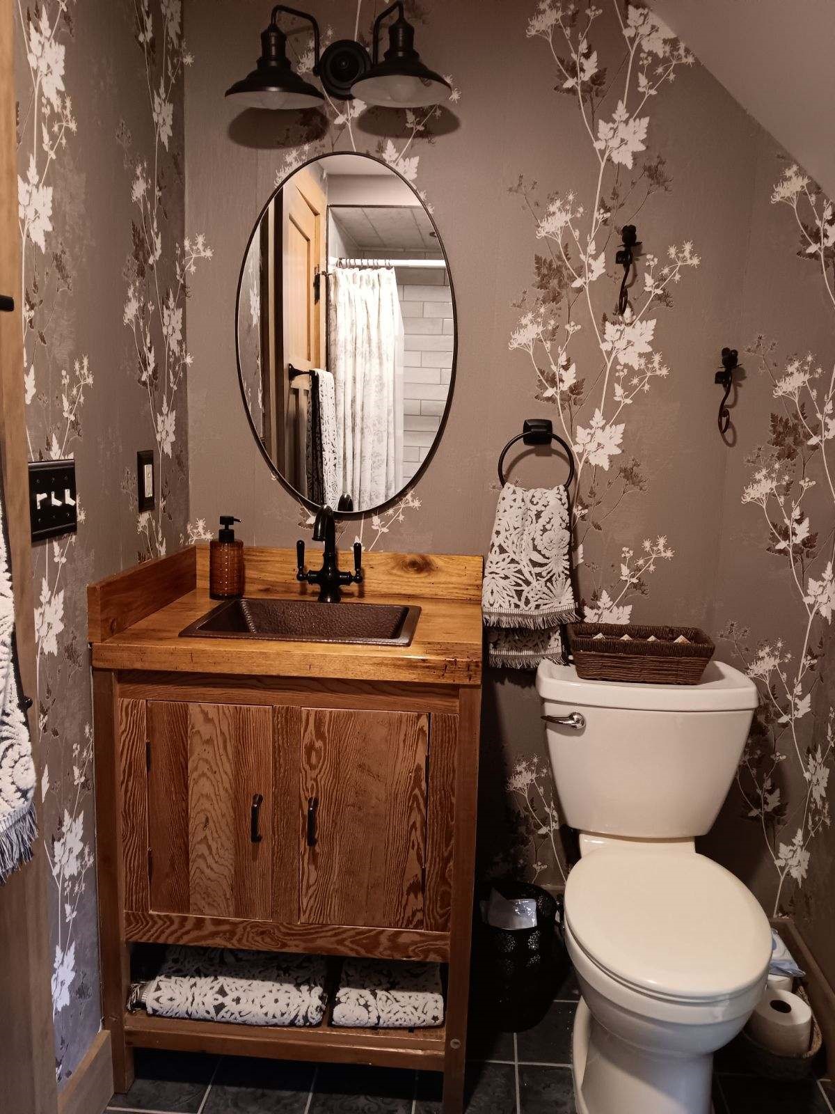 bathroom with grey flowered wall paper and updated rustic style appliances