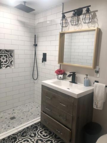 updated bathroom renovation with bold tile on floor and shower