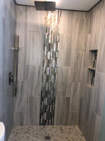ful shot of tile and waterfall shower in renovated bathroom