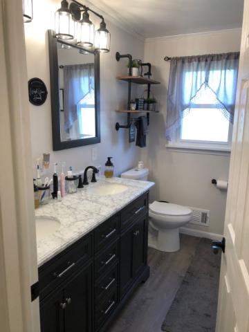 updated bathroom woth bold black accents and marble countertops