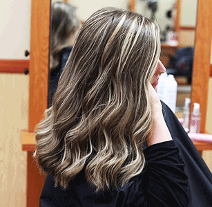 animated gif of a woman brushing her hands through her freshly curled hair