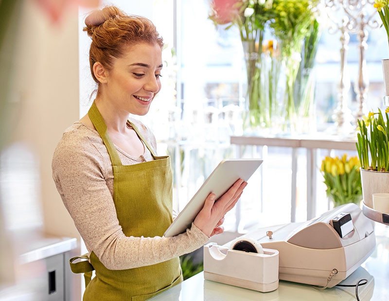 employee smiling while holding an ipad
