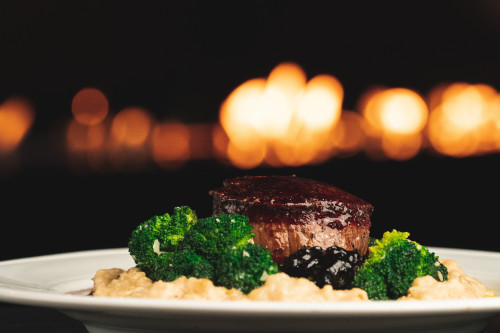 filet mignon over a bed of risotto and broccoli