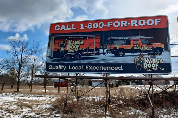 Billboard for Kanga Roof with their truck, trailer, and phone number: 1-800-FOR-ROOF.