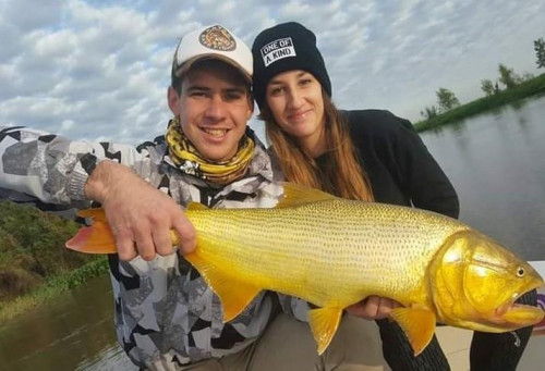 man and woman posing with fish