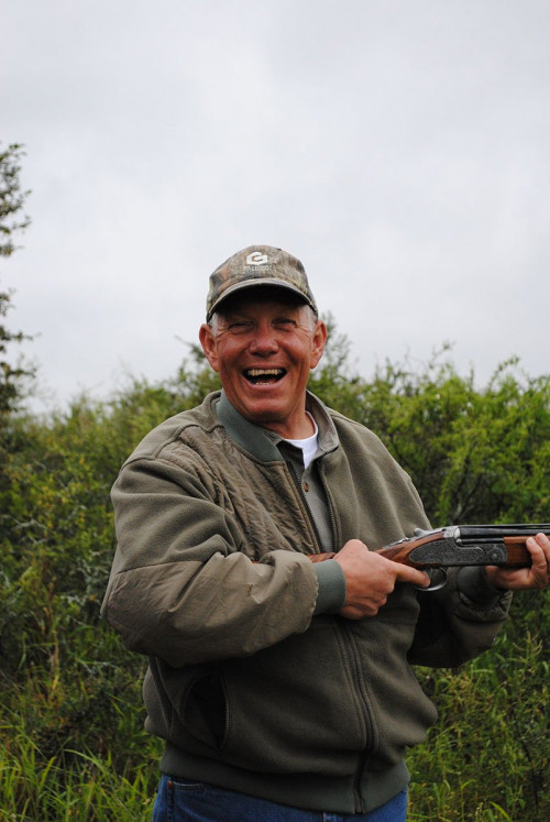 man posing with shotgun