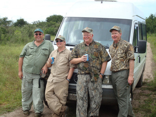 4 men in hunting gear near van