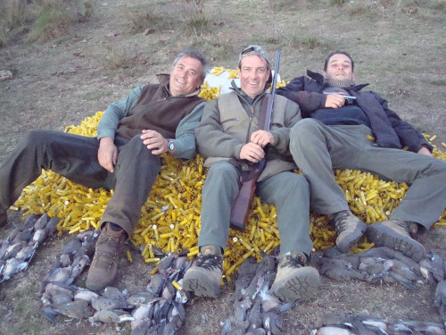 three men posing with hunting trophies