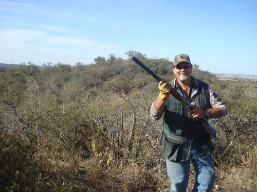 hunter posing in field with rifle