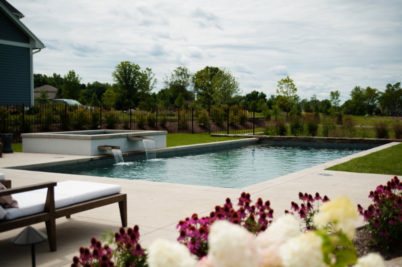 beautiful angular pool with flower in foreground and a hot tub