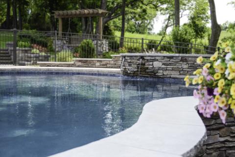 backyard pool with stone waterfall