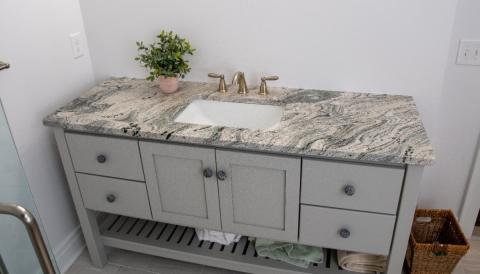 updated bathroom vaniet with gray cabinetry and marbled countertop