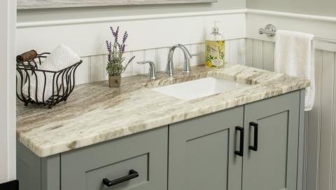 close up of bathroom sink with green-gray cabinets