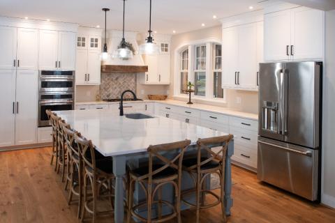 view of kitchen with white cabinets and white counter top and gray island