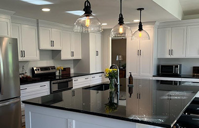 large modern kitchen with white cabients and black countertop