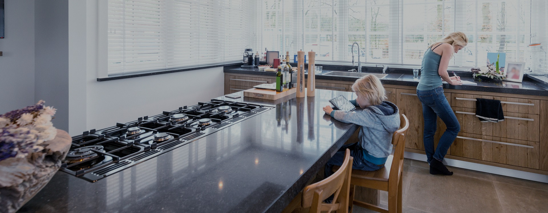 child sitting at table mom standing at kitchen counter