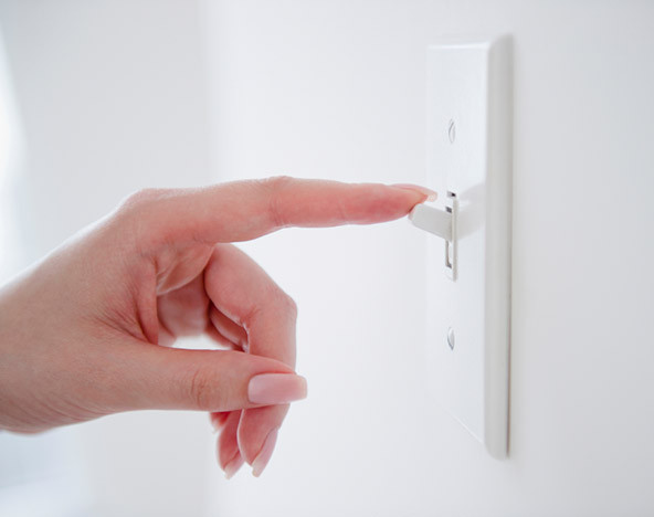hand turning on a wall switch