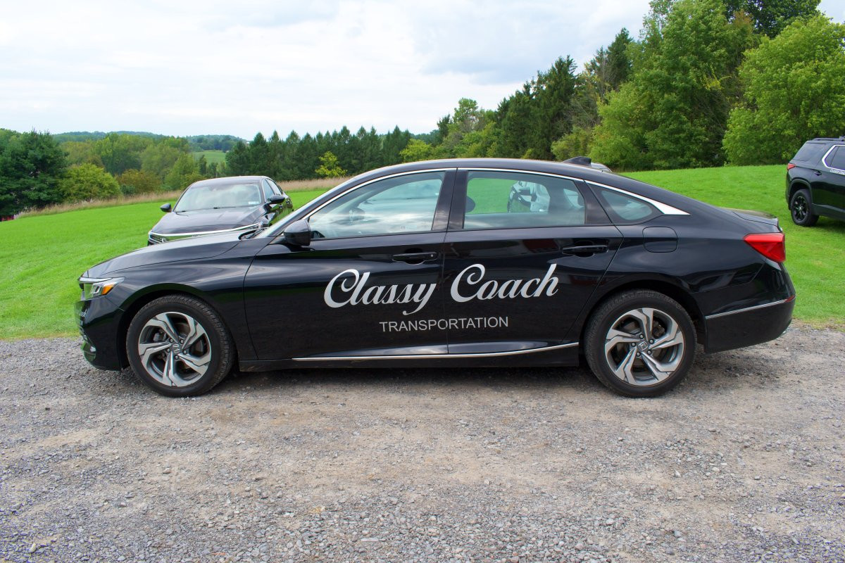 black sedan side view classy coach transportation
