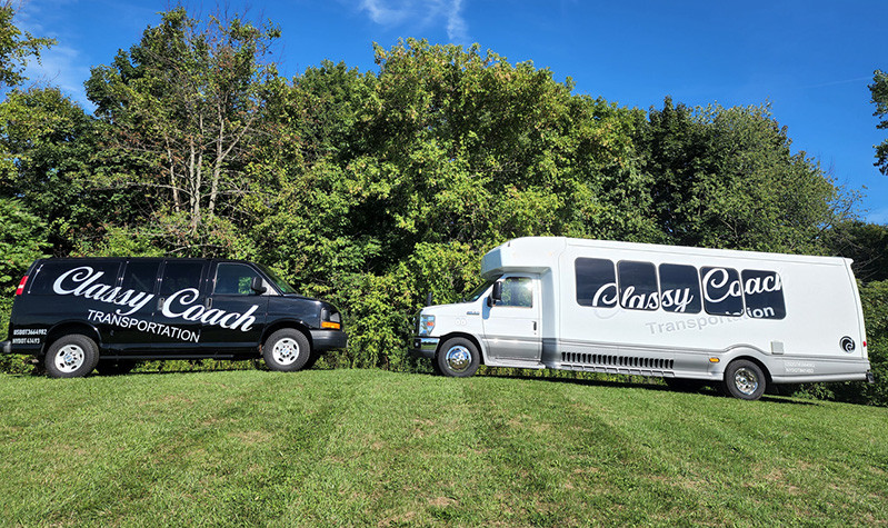 classy coach transportation black van and white party bus on a grassy hill